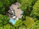 Expansive aerial view of a beautiful home with a large pool, deck and landscaped backyard nestled among mature trees at 7401 Heartland Dr, Wake Forest, NC 27587
