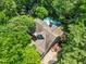 Aerial view of a beautiful home featuring a pool and deck, nestled among lush trees at 7401 Heartland Dr, Wake Forest, NC 27587