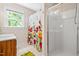 Well-lit bathroom featuring a walk-in shower, floral curtain, and tiled floors at 7401 Heartland Dr, Wake Forest, NC 27587