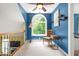 Bright bonus room with charming chair and arched window overlooking the lush landscape at 7401 Heartland Dr, Wake Forest, NC 27587