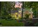 Charming brick home with manicured lawn and landscape illuminated at dusk offering inviting curb appeal at 7401 Heartland Dr, Wake Forest, NC 27587