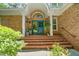 Inviting brick front entrance with arched doorway, brick steps, mature plants, and decorative accents at 7401 Heartland Dr, Wake Forest, NC 27587