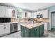 Bright kitchen featuring white cabinets, granite countertops, stainless steel appliances, and center island at 7401 Heartland Dr, Wake Forest, NC 27587