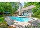 Backyard view of a pool with seating and the rear of a house on a sunny day at 7401 Heartland Dr, Wake Forest, NC 27587