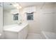 Bright bathroom with white cabinets, quartz countertop, and a window above the sink at 7605 Sandy Lake Ct, Raleigh, NC 27613