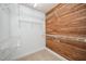 Spacious closet with wood paneled accent wall, white wire shelving, and neutral carpeting for ample storage at 7605 Sandy Lake Ct, Raleigh, NC 27613