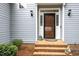 Inviting entryway with a wooden front door, decorative sidelights, and brick steps at 7605 Sandy Lake Ct, Raleigh, NC 27613