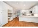 Open concept kitchen featuring white cabinetry, stainless appliances, and hardwood floors at 7605 Sandy Lake Ct, Raleigh, NC 27613