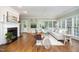 Inviting living room with a painted brick fireplace and bright light from many large windows at 7605 Sandy Lake Ct, Raleigh, NC 27613