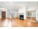 Spacious living room with hardwood floors, a white fireplace, and large windows at 7605 Sandy Lake Ct, Raleigh, NC 27613