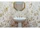 Charming powder room with floral wallpaper, a pedestal sink, and a decorative mirror at 7605 Sandy Lake Ct, Raleigh, NC 27613