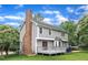 Back exterior featuring a brick chimney, deck, and well-maintained lawn at 8121 Bentwood Pl, Raleigh, NC 27615
