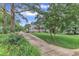 Charming gray two-story house with red front door has a long driveway, lush landscaping, and mature trees at 8121 Bentwood Pl, Raleigh, NC 27615