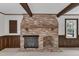 Living room brick fireplace with wood mantle and wood beams at 8121 Bentwood Pl, Raleigh, NC 27615
