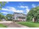 Charming gray two-story home with a well-manicured front yard, mature trees, and long driveway at 8121 Bentwood Pl, Raleigh, NC 27615
