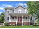 Charming two-story home features a welcoming front porch and well-manicured lawn and red double front doors at 8121 Bentwood Pl, Raleigh, NC 27615