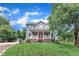 Charming two-story home features a well-manicured lawn, mature trees, and classic architecture with a red front door at 8121 Bentwood Pl, Raleigh, NC 27615