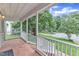 Covered front porch with brick flooring and white railings and columns, providing a cozy outdoor space at 8121 Bentwood Pl, Raleigh, NC 27615