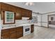 Kitchen with tiled floors, wood cabinetry, and a view to a breakfast nook with a bay window at 8121 Bentwood Pl, Raleigh, NC 27615