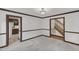 Open floor plan showcasing a living area with gray carpet, traditional trim, and staircase access at 8121 Bentwood Pl, Raleigh, NC 27615