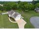 A back aerial view reveals a landscaped yard, a charming back patio, and a spacious driveway for parking at 817 Mossy Oak Dr, Fuquay Varina, NC 27526