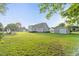 Expansive backyard with lush green grass, a swing set, and detached garage at 817 Mossy Oak Dr, Fuquay Varina, NC 27526