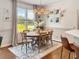 Bright dining room features wood floors, decorative rug, and a modern light fixture above the wood dining table at 817 Mossy Oak Dr, Fuquay Varina, NC 27526