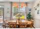Bright dining room features wood floors, decorative rug, and a modern light fixture above the wood dining table at 817 Mossy Oak Dr, Fuquay Varina, NC 27526