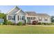 Charming single-story home featuring manicured lawn, gray siding, and a welcoming front porch at 817 Mossy Oak Dr, Fuquay Varina, NC 27526