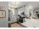 Bright kitchen with white cabinets, stainless steel appliances, decorative backsplash and quartz countertops at 817 Mossy Oak Dr, Fuquay Varina, NC 27526