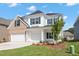 Charming two-story home with white siding, brick accents, a three-car garage, and a well-manicured lawn at 84 Black Walnut Dr # 200, Garner, NC 27529