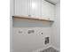 Bright laundry area featuring overhead cabinets and patterned tile floor at 84 Black Walnut Dr # 200, Garner, NC 27529