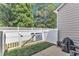 Backyard patio featuring a Weber grill, seating, and a white privacy fence at 886 Cupola Dr, Raleigh, NC 27603