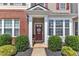 Inviting front door with decorative wreath, enhanced by lush landscaping and charming architectural details at 886 Cupola Dr, Raleigh, NC 27603