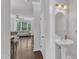 View from powder room into a living room with hardwood floors and neutral decor at 886 Cupola Dr, Raleigh, NC 27603