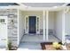 Inviting front porch with stone accents, a stylish black door, and classic white support columns at 96 Northwood Dr, Fuquay Varina, NC 27526