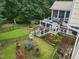 Aerial view showcasing multi-level deck, fenced yard, garden features and lush, green landscape at 10415 Ashmead Ln, Raleigh, NC 27614
