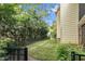 Grassy backyard with black fence around the property, surrounded by mature trees and landscaping at 10415 Ashmead Ln, Raleigh, NC 27614