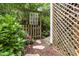 Enchanting backyard gate with stepping stones and lush greenery, leading to serene gardens at 10415 Ashmead Ln, Raleigh, NC 27614