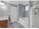 Gray tiled bathroom with bathtub and walk-in shower at 10415 Ashmead Ln, Raleigh, NC 27614