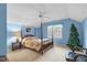 Blue-walled bedroom featuring a four-poster bed, ceiling fan, window, and carpeted floor at 10415 Ashmead Ln, Raleigh, NC 27614