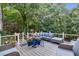 Inviting deck with wicker furniture and colorful planters overlooks a lush, wooded backyard at 10415 Ashmead Ln, Raleigh, NC 27614