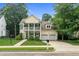 Charming yellow two-story home with double front porch, well-manicured lawn and a two-car garage at 10415 Ashmead Ln, Raleigh, NC 27614