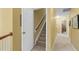 Hallway featuring carpet, a white door, and stairs leading to the upper level of the home at 10415 Ashmead Ln, Raleigh, NC 27614