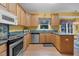 Spacious kitchen featuring wooden cabinets, stainless steel appliances, and marble countertops at 10415 Ashmead Ln, Raleigh, NC 27614