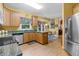 Bright kitchen with stainless steel refrigerator, stone countertops, and breakfast nook at 10415 Ashmead Ln, Raleigh, NC 27614