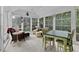 Bright sunroom with multiple windows, tile flooring, a dining table and comfortable seating at 10415 Ashmead Ln, Raleigh, NC 27614