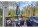 Outdoor dining deck with an umbrella, a glass top table, chairs, and a grill, perfect for entertaining at 108 Rocking Horse Ln, Sanford, NC 27332