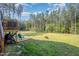 Inviting backyard with a wooden deck, green lawn, tall pine trees, and plenty of space for outdoor activities and relaxation at 108 Rocking Horse Ln, Sanford, NC 27332