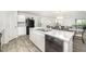 Well-lit kitchen island featuring marble countertops, a double sink, and views into the adjacent living and dining spaces at 108 Rocking Horse Ln, Sanford, NC 27332